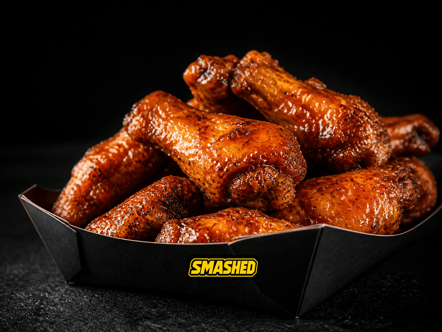 Fifteen sauced wings in a black SMASHED box