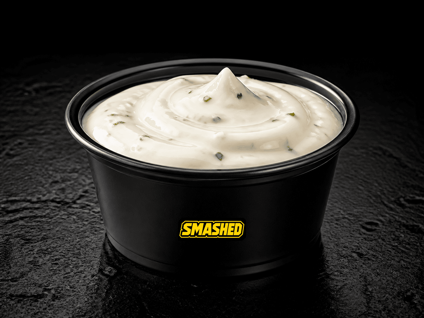 Garlic aioli sauce cup on a black counter