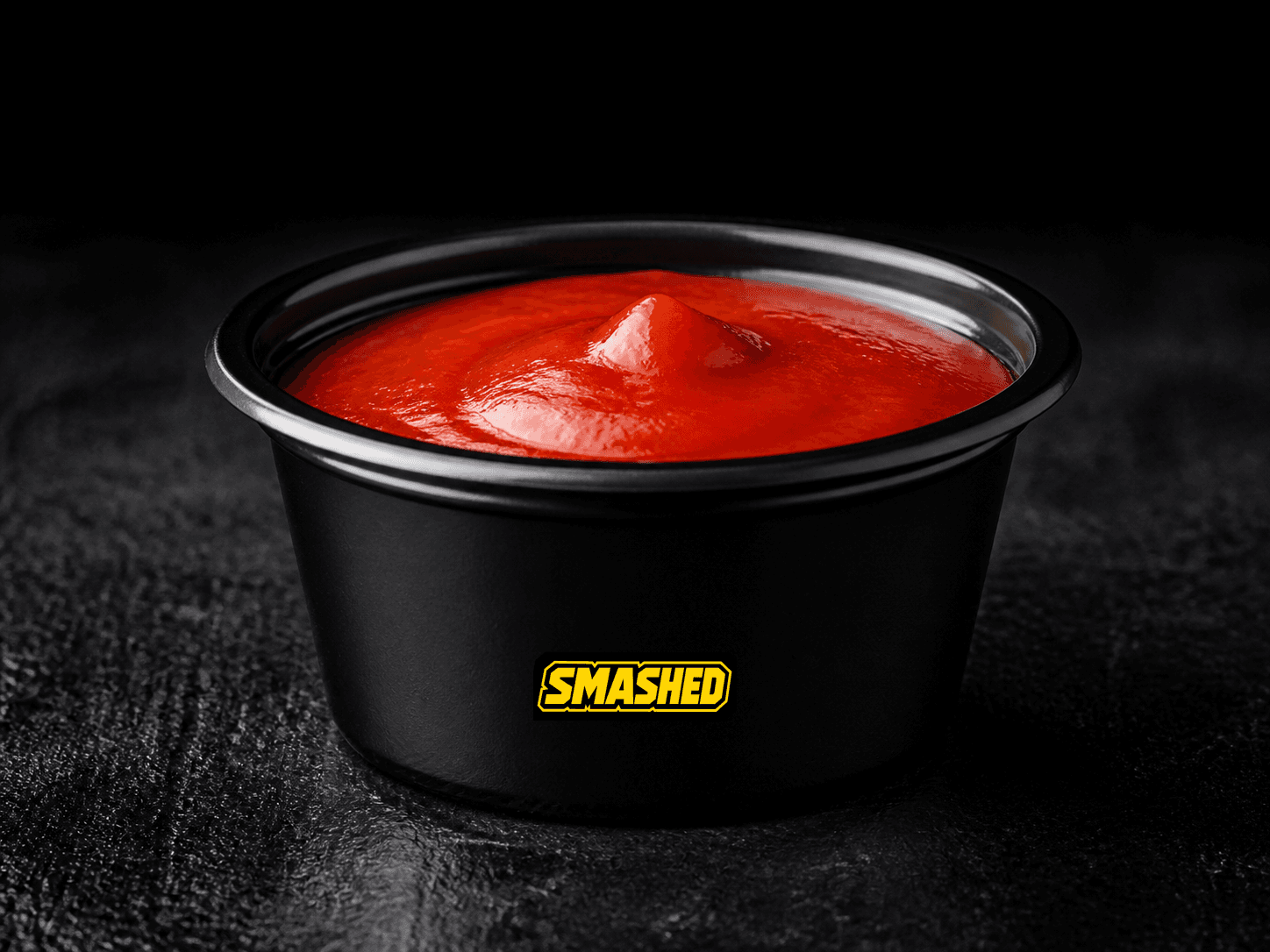 Hot sauce cup on a black counter