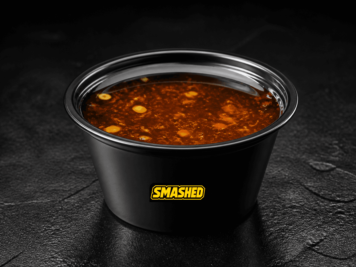 Hot honey sauce cup on a black counter